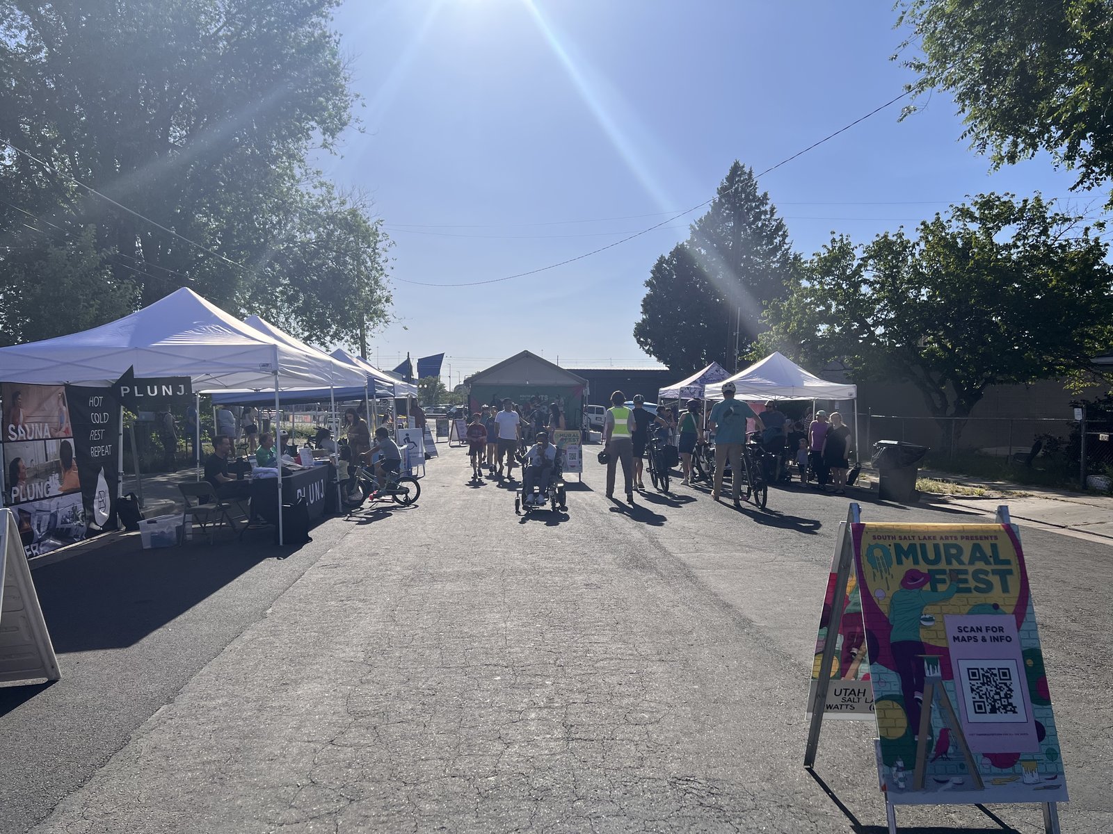 Festival-goers walking through Mural Fest past a Mural Fest sign